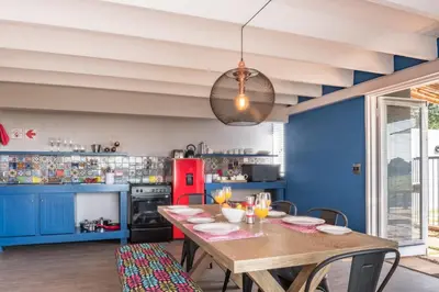 a dining room with a table and a red refrigerator at Bluemere Living in White River