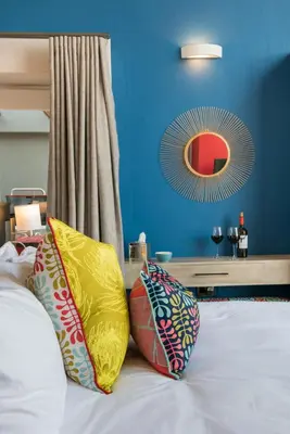 a bed with pillows on it with a blue wall at Bluemere Living in White River