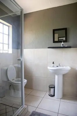 a bathroom with a toilet and a sink at Impala Lily in Marloth Park