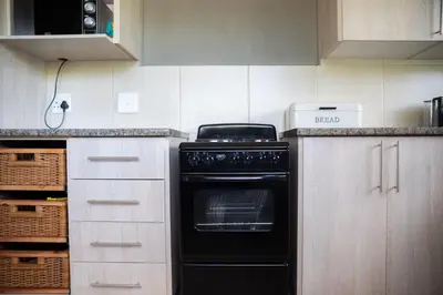 a kitchen with a black oven in the middle at Impala Lily in Marloth Park