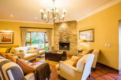 a living room with couches and a stone fireplace at Sondela Nature Reserve & Spa Country House in Bela-Bela