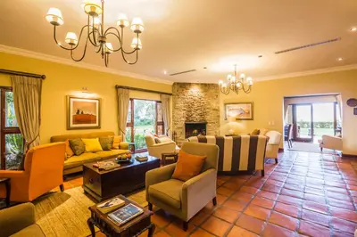 a living room filled with furniture and a fireplace at Sondela Nature Reserve & Spa Country House in Bela-Bela