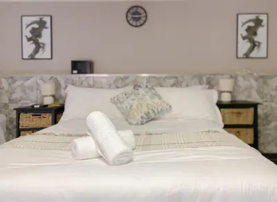 a white bed with two rolled towels on it at The Ultimate Lodge in Louis Trichardt