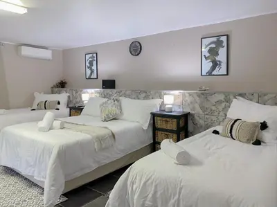 a bedroom with two beds with white sheets at The Ultimate Lodge in Louis Trichardt