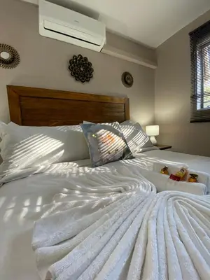 a white bed with two teddy bears on it at The Ultimate Lodge in Louis Trichardt