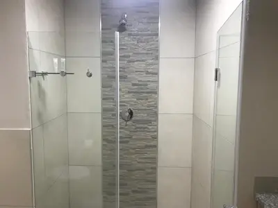 a shower with a glass door in a bathroom at Regal Inn Hotel Midrand in Midrand