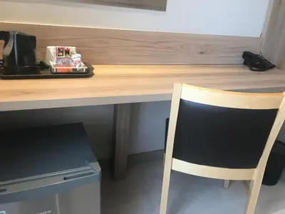 a wooden desk with a chair in front of a counter at Regal Inn Hotel Midrand in Midrand