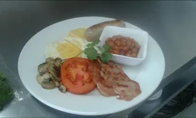 a plate of food with meat and vegetables and beans at Regal Inn Hotel Midrand in Midrand