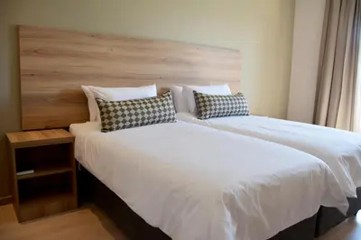 a bedroom with a large bed with a wooden headboard at Regal Inn Hotel Midrand in Midrand