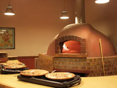 a pizza oven with several pizzas on a counter at Crystal Springs Mountain Lodge in Pilgrimʼs Rest