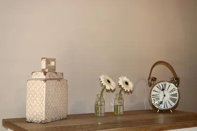 a shelf with flowers and a clock and a basket at Luvivane Luxury Villa in Marloth Park