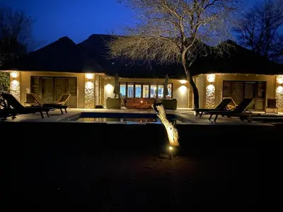 a house with a swimming pool at night at Luvivane Luxury Villa in Marloth Park