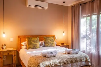a bedroom with a bed with towels on it at The Porcupine Porch in Marloth Park