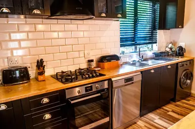 a kitchen with a stove top oven next to a sink at The Porcupine Porch in Marloth Park