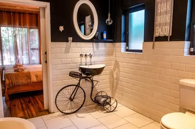 a bike parked in a bathroom with a sink at The Porcupine Porch in Marloth Park
