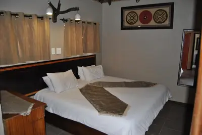 a bedroom with two beds with white sheets at Mabalingwe Elephant Lodge in Bela-Bela