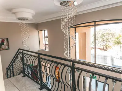 a staircase with a chandelier in a house at Khutso Boutique Hotel in Hazyview
