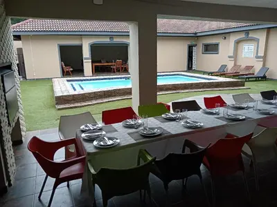 a table and chairs in a room with a pool at Khutso Boutique Hotel in Hazyview