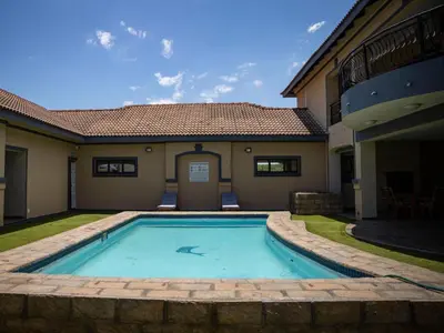 a swimming pool in the backyard of a house at Khutso Boutique Hotel in Hazyview