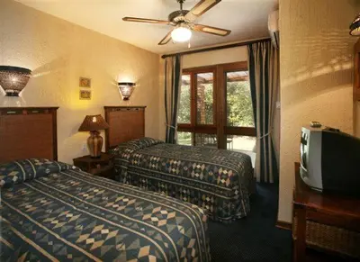 a hotel room with two beds and a television at Kruger Park Lodge 401 in Hazyview