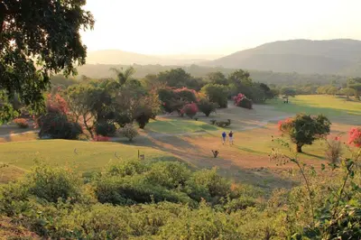 two people walking on a hill in a field at Kruger Park Lodge 401 in Hazyview