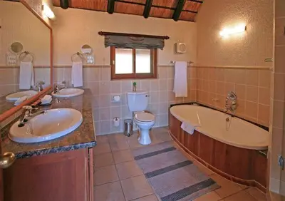 a bathroom with a tub and a sink and a toilet at Kruger Park Lodge 401 in Hazyview