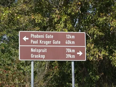 a brown street sign in front of a tree at Kruger Park Lodge 401 in Hazyview