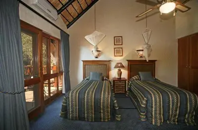 a bedroom with two beds and a window at Kruger Park Lodge 401 in Hazyview