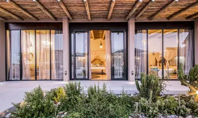 a house with large glass doors and windows at Kruger Sunset Lodge in Hectorspruit