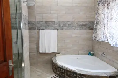 a bathroom with a bath tub and a shower at The Highlander Hotel Dullstroom in Dullstroom