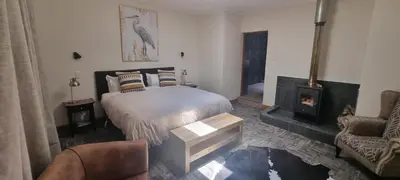 a bedroom with a bed and a wood stove at The Highlander Hotel Dullstroom in Dullstroom