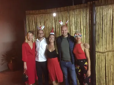 a group of people wearing christmas hats posing for a picture at Safari Club Guest Lodge OR Tambo International Airport in Kempton Park