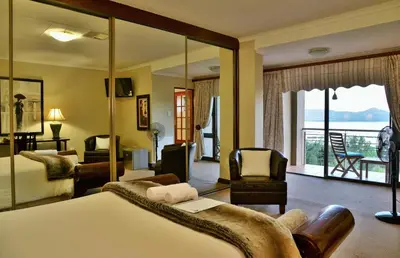 a hotel room with a bed and a balcony at Stirling Manor Boutique Guest House in Hartbeespoort