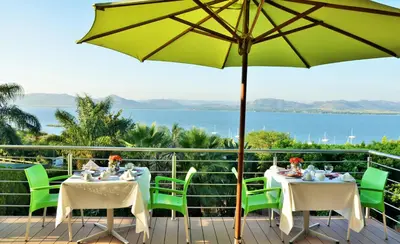 a patio with tables and chairs and an umbrella at Stirling Manor Boutique Guest House in Hartbeespoort