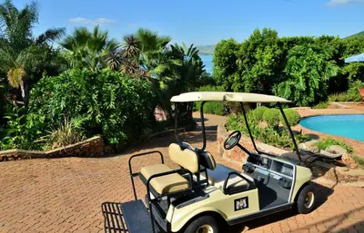 a golf cart is parked next to a pool at Stirling Manor Boutique Guest House in Hartbeespoort