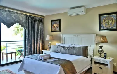 a bedroom with a large bed and a balcony at Stirling Manor Boutique Guest House in Hartbeespoort
