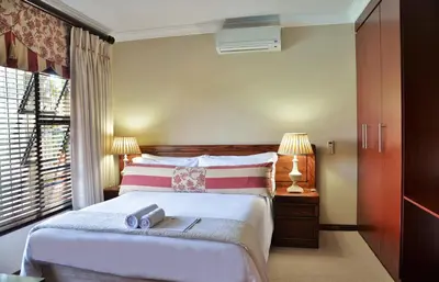 a bedroom with a bed with a book on it at Stirling Manor Boutique Guest House in Hartbeespoort