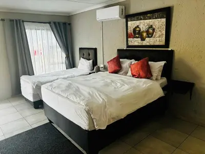 a hotel room with two beds and a window at BTV Guesthouse in Hazyview