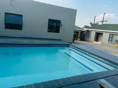 a swimming pool in front of a house at BTV Guesthouse in Hazyview