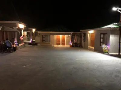 an empty parking lot in front of a house at night at BTV Guesthouse in Hazyview