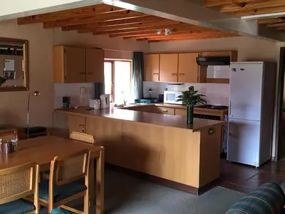 a kitchen with a table and a white refrigerator at Marigold's 37 Critchley Common in Dullstroom