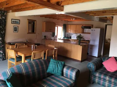 a living room with a table and a kitchen at Marigold's 37 Critchley Common in Dullstroom