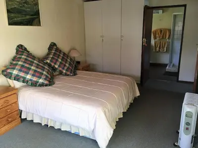 a bedroom with a bed withkered pillows on it at Marigold's 37 Critchley Common in Dullstroom