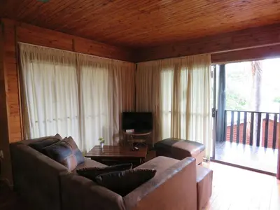 a living room with a couch and a television at Viewpoint Lodge & Safari Tours in Hazyview