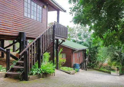 a house with a wooden staircase next to a building at Viewpoint Lodge & Safari Tours in Hazyview