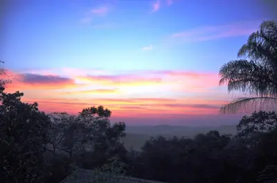 a sunset in the sky with trees in the foreground at Viewpoint Lodge & Safari Tours in Hazyview