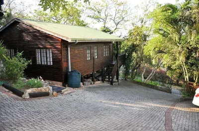 a small cabin with a porch and a fence at Viewpoint Lodge & Safari Tours in Hazyview