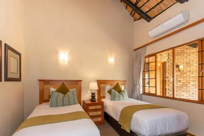a bedroom with two beds and a window at Kruger Park Lodge Unit No 252 with private pool in Hazyview