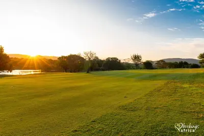 a field of green grass with the sun in the background at Kruger Park Lodge Unit No 252 with private pool in Hazyview