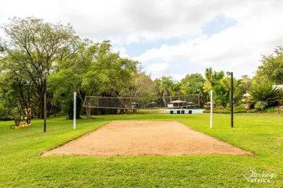 a field with a volleyball net in a park at Kruger Park Lodge Unit No 252 with private pool in Hazyview